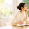 ノートを書きながら自分との関係を見つめ直し、本来の自分に戻る時間を過ごす女性