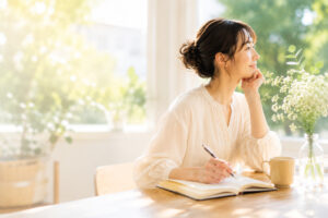 ノートを書きながら自分との関係を見つめ直し、本来の自分に戻る時間を過ごす女性