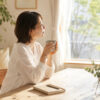 北海道の自然光が差し込む部屋でお茶を飲みながら自分と向き合う女性